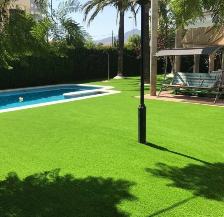 Jardín con césped artificial, palmeras y piscina en Gran Canaria